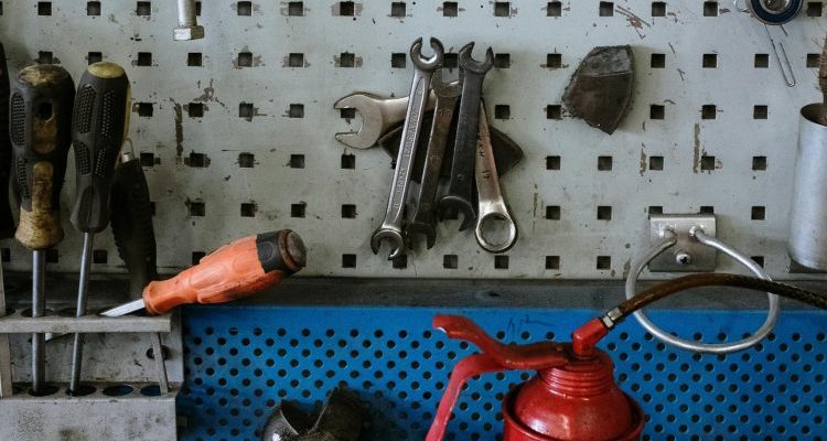 A neatly arranged set of automotive tools hanging on a workshop pegboard, emphasizing organization and efficiency.