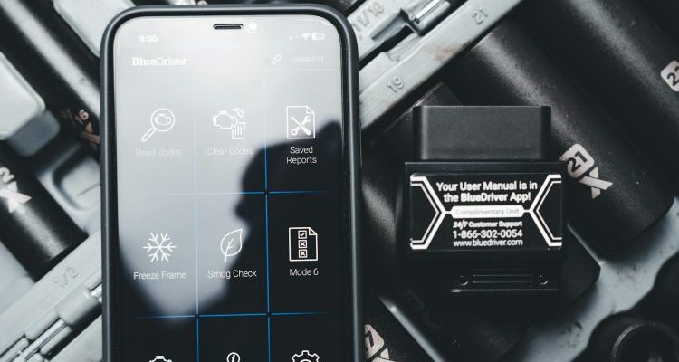 Close-up of a smartphone displaying a diagnostic app with a vehicle diagnostic tool and socket set.